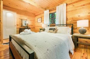 1 dormitorio con 1 cama y pared de madera en Pattersons Cabin-Nature Retreat-10 Mi to DT, en Garfield