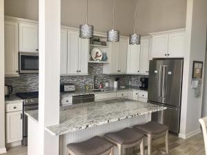 cocina con armarios blancos y encimera de granito en New Ocean Block Duplex, en Beach Haven