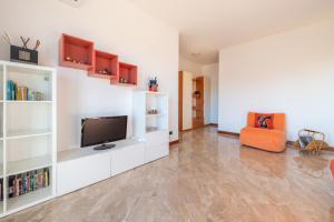 a living room with white shelves and a flat screen tv at Rainbow House. Rho Fiera Milano in Rho