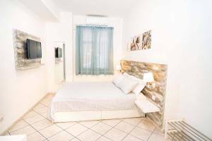 a bedroom with a bed and a tv on a wall at Taormina Beach House in Mazzeo