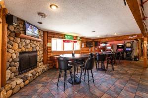 un restaurante con chimenea, mesas y sillas en Sleeps 7 Rustic Loft At Riviera Resort!, en Neillsville