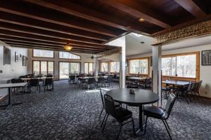 uma grande sala com mesas, cadeiras e janelas em Sleeps 7 Rustic Loft At Riviera Resort! em Neillsville