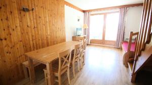 Un comedor con mesa y sillas de madera. en Résidence Parc Aux Etoiles - CH15PAE - CHALET DUPLEX 2 CHAMBRES, TERRASSE ET BALCON MAE-2194, en Narreyroux