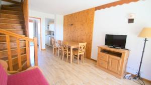 Sala de estar con mesa de comedor y TV en Résidence Parc Aux Etoiles - CH15PAE - CHALET DUPLEX 2 CHAMBRES, TERRASSE ET BALCON MAE-2194, en Narreyroux