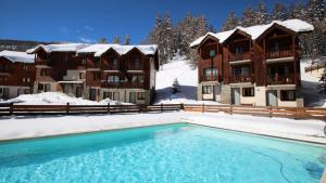 un complejo con piscina en la nieve en Résidence Parc Aux Etoiles - CH15PAE - CHALET DUPLEX 2 CHAMBRES, TERRASSE ET BALCON MAE-2194, en Narreyroux