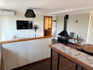 ein Wohnzimmer mit einer Bar und einem Flachbild-TV in der Unterkunft Impecable apartamento a 5 minutos de la terminal in Artigas