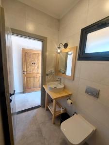 ein Bad mit einem Waschbecken, einem WC und einem Fenster in der Unterkunft Palamut Butik Otel in Datca