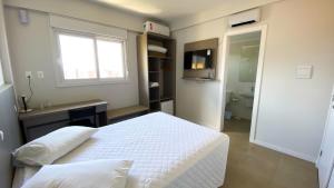 a bedroom with a bed and a sink and a window at ÓPER SMART HOTEL in Santa Maria