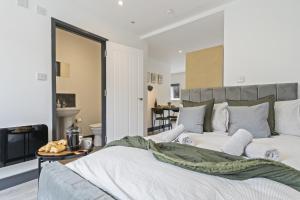 a bedroom with a large white bed and a fireplace at The Olive Suite in Ilkeston