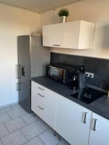 eine Küche mit einer Mikrowelle und einem Kühlschrank in der Unterkunft Gästehaus Brunswiek Obergeschoss in Vordorf