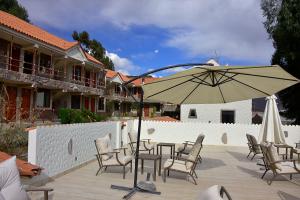 een tafel en stoelen met een parasol op een patio bij TerraMistica Colca in Coporaque