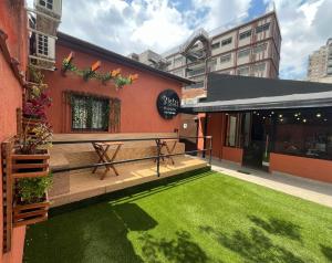 a building with a deck with a green lawn at Bistu Hotel - Vila Nova Conceição in Sao Paulo
