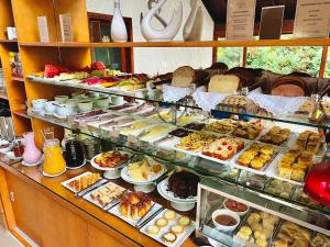 a display case in a bakery with many different pastries at Pousada do Lago in Gramado