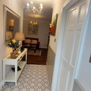 a hallway with a white door and a living room at Russell Mews in Ennis