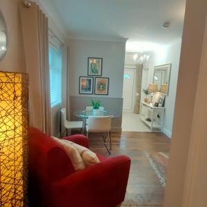 Russell Mews في اينيس: غرفة معيشة مع كرسي احمر وطاولة