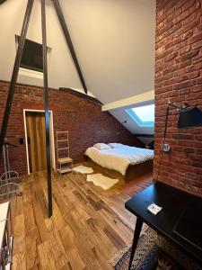 a bedroom with a bed and a brick wall at Villa Sonneville (Vauban - Barbieux) in Roubaix