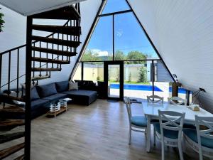a living room with a couch and a table with chairs at Qafqaz Gabala Twin A Frame Villas in Gabala