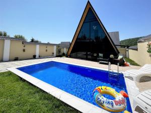 una piscina con una balsa inflable frente a una casa en Gabala Twin A Frame Villas en Gabala