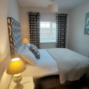 Un dormitorio con una cama grande y una ventana en Russell Mews, en Ennis
