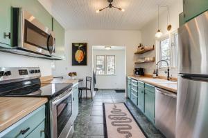 a kitchen with green cabinets and a stainless steel refrigerator at Saint Paul Vacation Rental Near Shopping and Dining! in Saint Paul