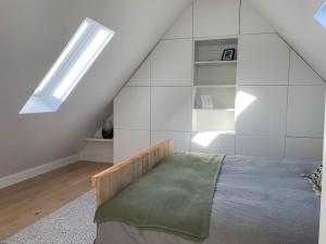 a bedroom with a bed and a skylight at The Conservatory, a cosy holiday home located central between Gent Antwerpen & Brussel in Lokeren