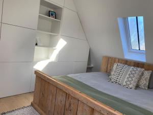 a bedroom with a wooden bed and a window at The Conservatory in Lokeren