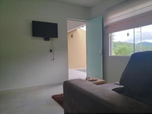 Casa Completa da Magui - 02 في بوميرودي: غرفة معيشة مع أريكة ونافذة