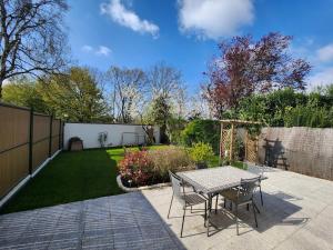 eine Terrasse mit einem Tisch und Stühlen im Hinterhof in der Unterkunft Maison loft avec jardin pour 6 voyageurs entre Paris et Disneyland in Torcy