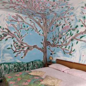 um quarto com um mural de árvore na parede em Room e Breakfast Diana e Ninni Salsomaggiore Terme em Salsomaggiore Terme