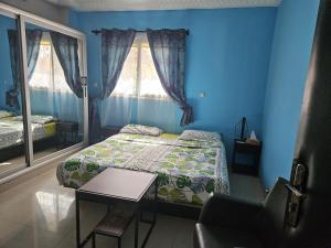 sypialnia z łóżkiem i stołem w obiekcie Villa L'Oasis w mieście Wagadugu