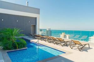 a pool on the roof of a building with chairs at Exclusive Luxury Jr Suite 1BRD By ENCOR in Gaira