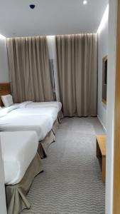 a row of beds in a hotel room at فندق سدرة المحبس in Al Khansāk