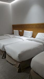 a group of three beds in a room at فندق سدرة المحبس in Al Khansāk