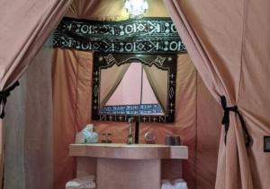 a bathroom with a sink and a mirror at Amazing Luxury Camp in Merzouga