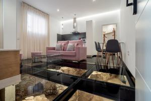 uma sala de estar com uma mesa de vidro e um sofá em Apartamentos CMDreams Gold- ruinas romanas a tus pies- parking privado em Mérida