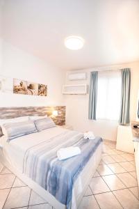 a bedroom with a large bed with blue and white sheets at Taormina Beach House in Mazzeo