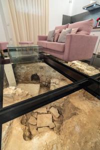 uma sala de estar com um sofá e uma mesa de vidro em Apartamentos CMDreams Gold- ruinas romanas a tus pies- parking privado em Mérida