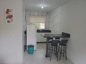 a kitchen with a black counter and a refrigerator at Casa Completa da Magui - 02 in Pomerode