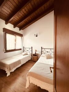 a bedroom with two beds and a window at Los Castros Apartamentos Rurales B in Llames de Pría