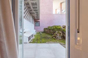 uma porta de vidro que leva a uma casa de banho com um quintal em Apartamentos CMDreams Gold- ruinas romanas a tus pies- parking privado em Mérida