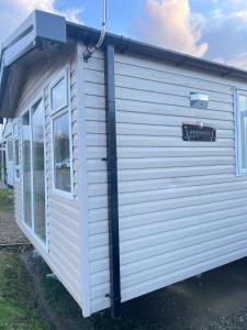 a white tiny house with a sign on it at F14 in Sandown