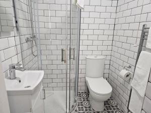 a white bathroom with a toilet and a sink at The Ivernia hotel in Skegness