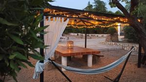 een hangmat en een tafel onder een luifel met verlichting bij Casa Rural MONTE VERDE in Illana