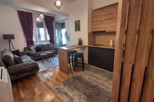 a living room with a couch and a table and a kitchen at Apartment Ole Stuga in Struga
