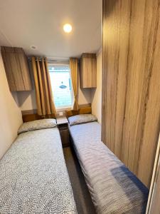 two beds in a small room with a window at F14 in Sandown