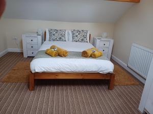 a bedroom with a bed with two teddy bears on it at Acorn Cottage, Ashover in Ashover