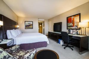 a hotel room with a bed and a desk at Holiday Inn Vancouver-Centre Broadway by IHG in Vancouver
