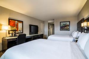 a hotel room with two beds and a desk at Holiday Inn Vancouver-Centre Broadway, an IHG Hotel in Vancouver