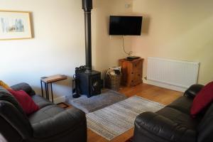 Acorn Cottage, Ashover في Ashover: غرفة معيشة مع أريكة وموقد