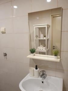 Baño blanco con lavabo y espejo en Airbnb Veriora, en Veriora